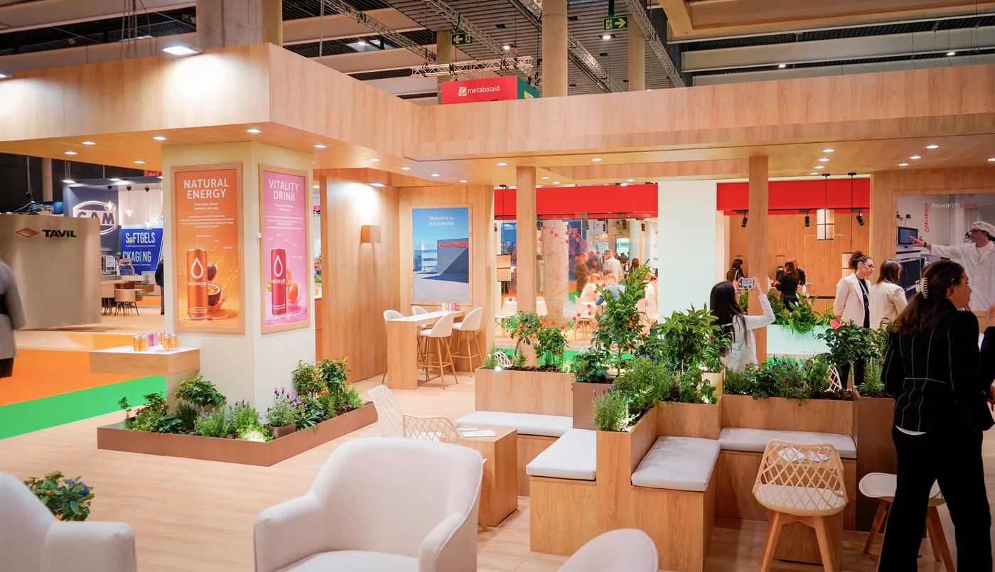 Stand de feria montado por ROCMA — stand cálido de madera con vegetación
